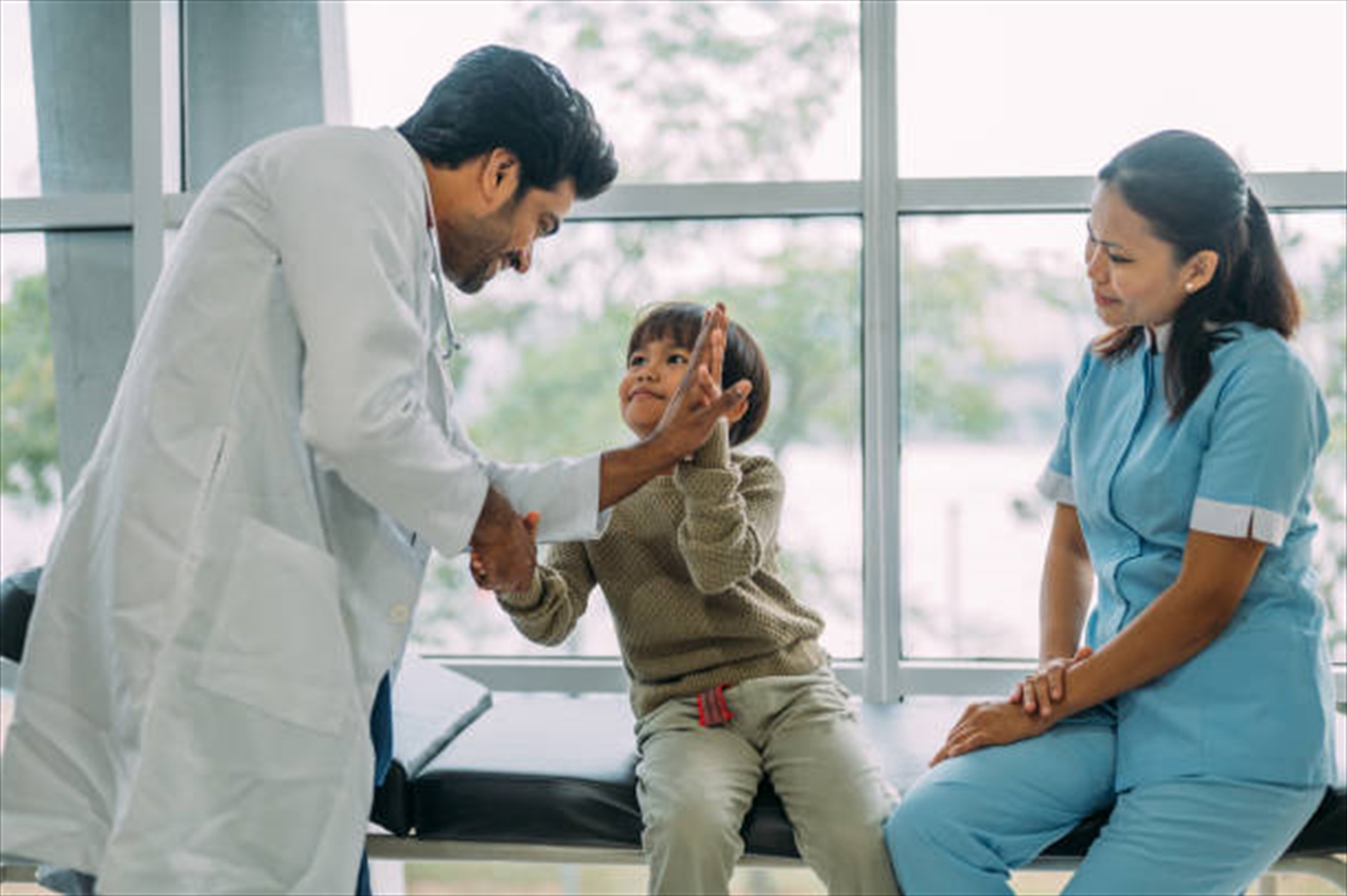 Pediatrician high-fiving a child at Opal Hospital